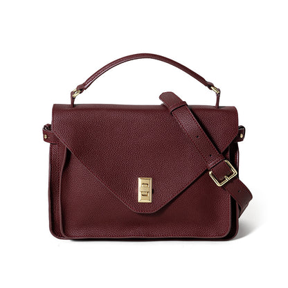 Brown leather handbag with gold clasp on a white background