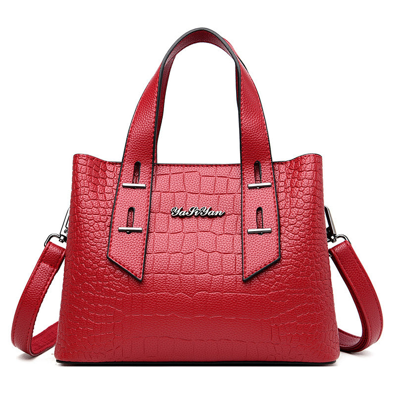 Red handbag with a textured pattern and visible brand name on a white background